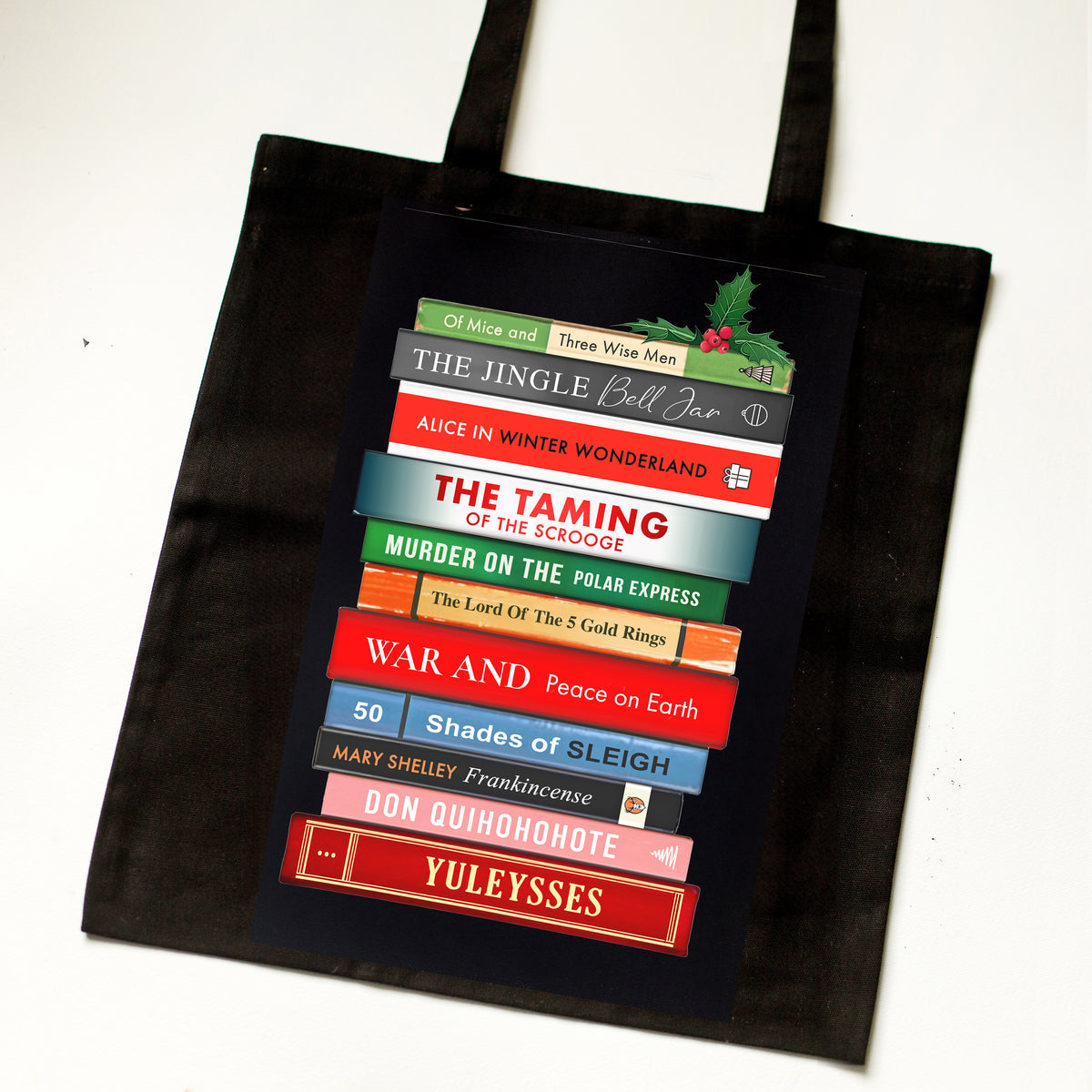 Black tote bag with colorful book design on a white background