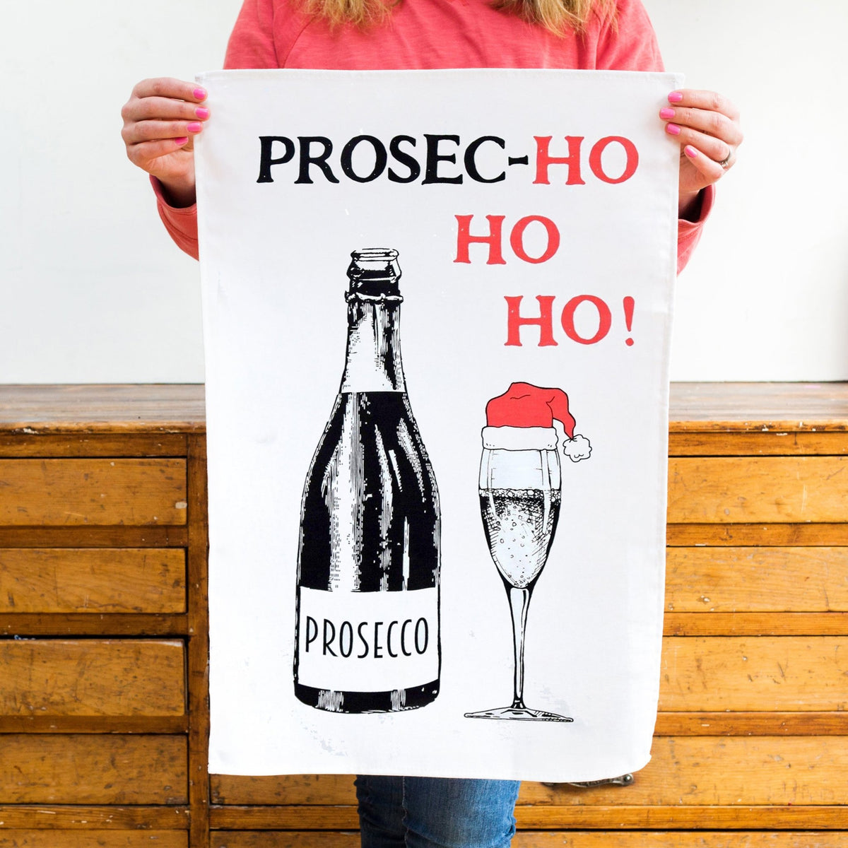 Person holding a towel with Prosecco-themed design and text.