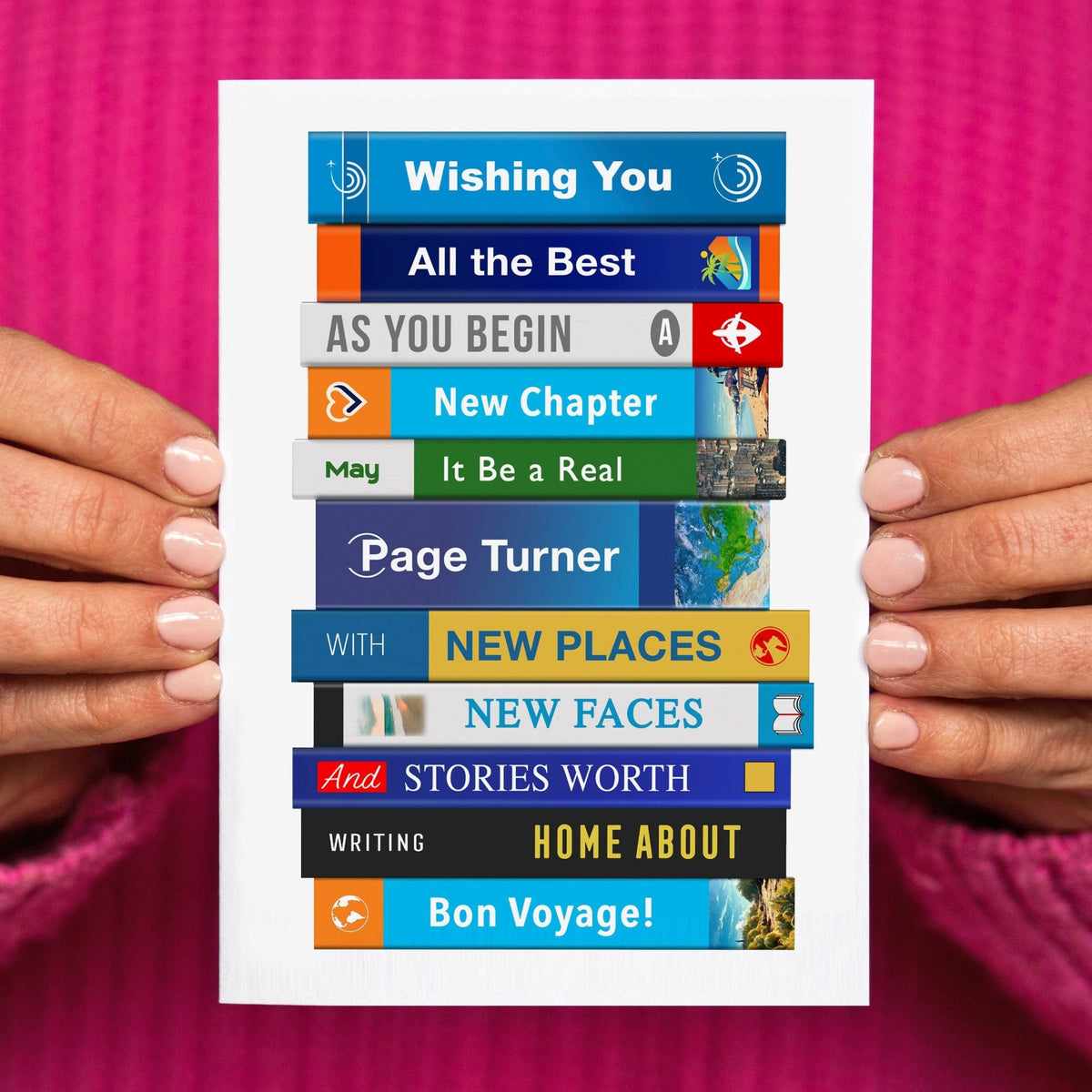 Person holding a colorful 'Bon voyage' card with illustrations of travel guides featuring book themed phrases on a pink background