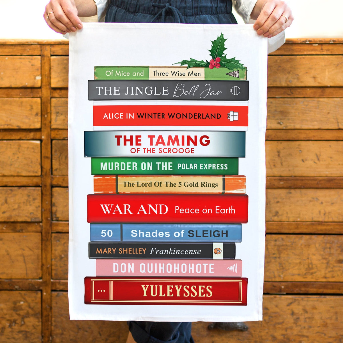 a christmas tea towel featuring a stack of books