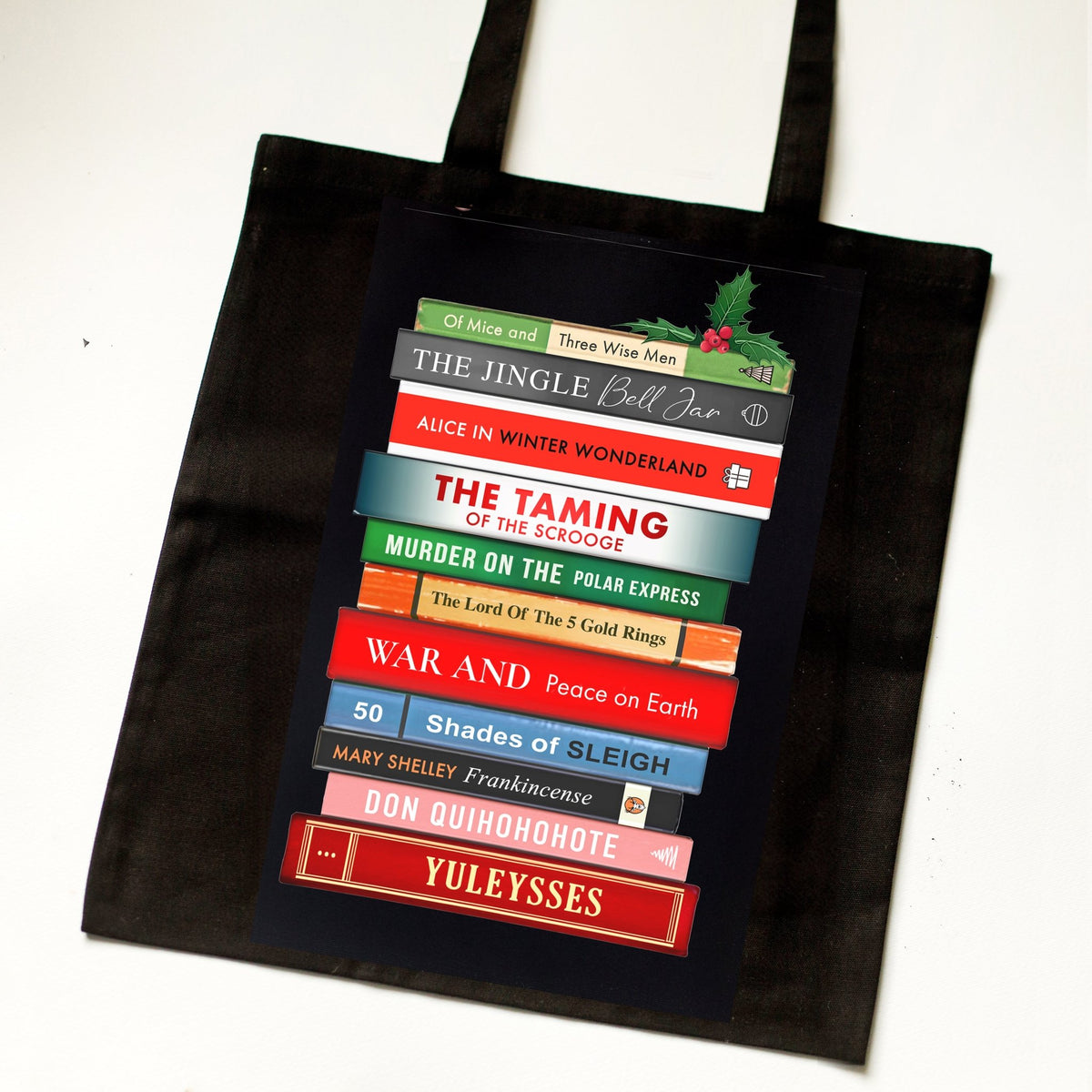 Black tote bag with colorful book design on a white background