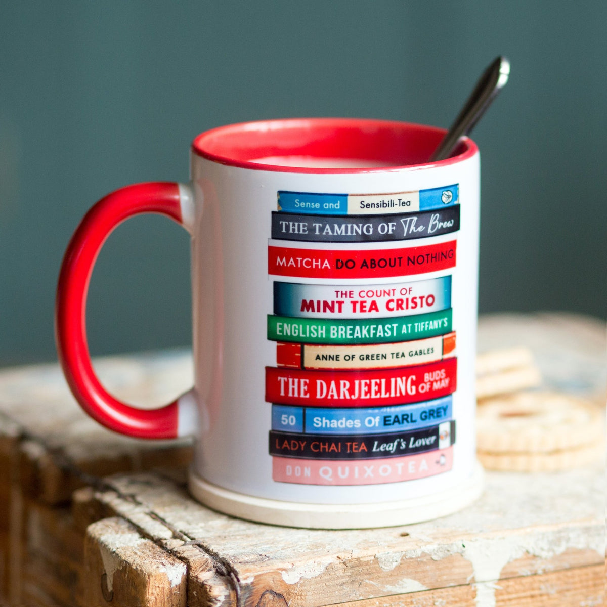 a mug wth a stack of book designs full of literary tea puns on a wooden table