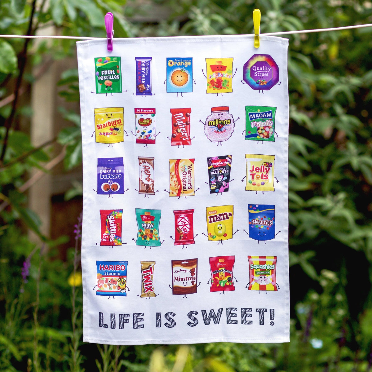 tea towel hanging on a washing line featuring illustrations of different sweets
