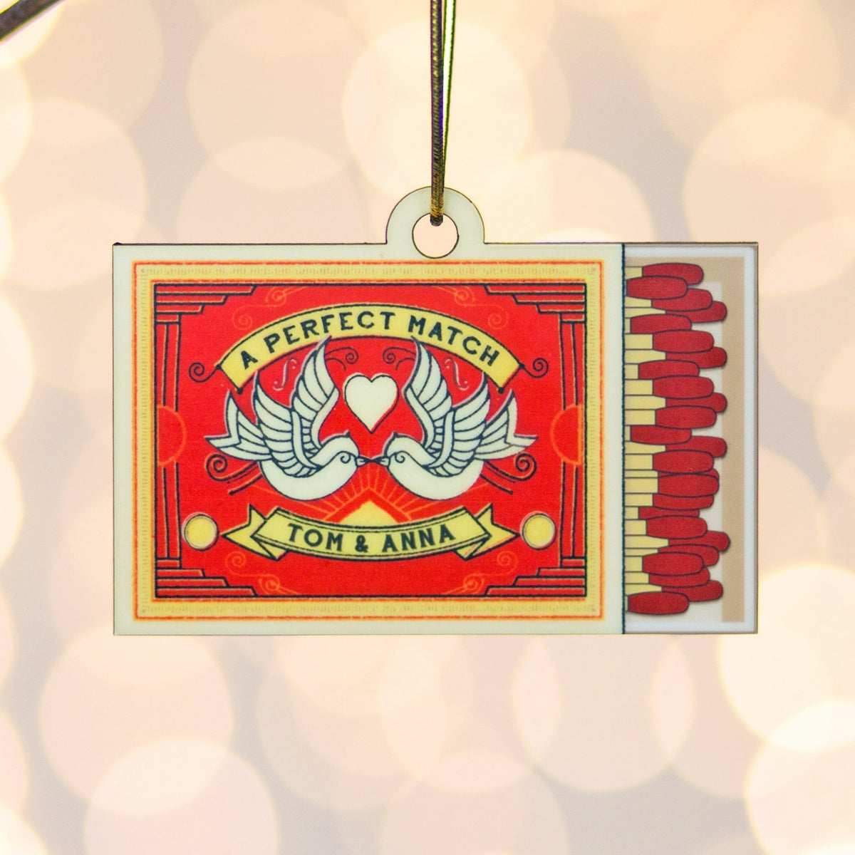 Decorative matchbox ornament with 'A Perfect Match' text and dove design, personalized with names 'Tom & Anna'.