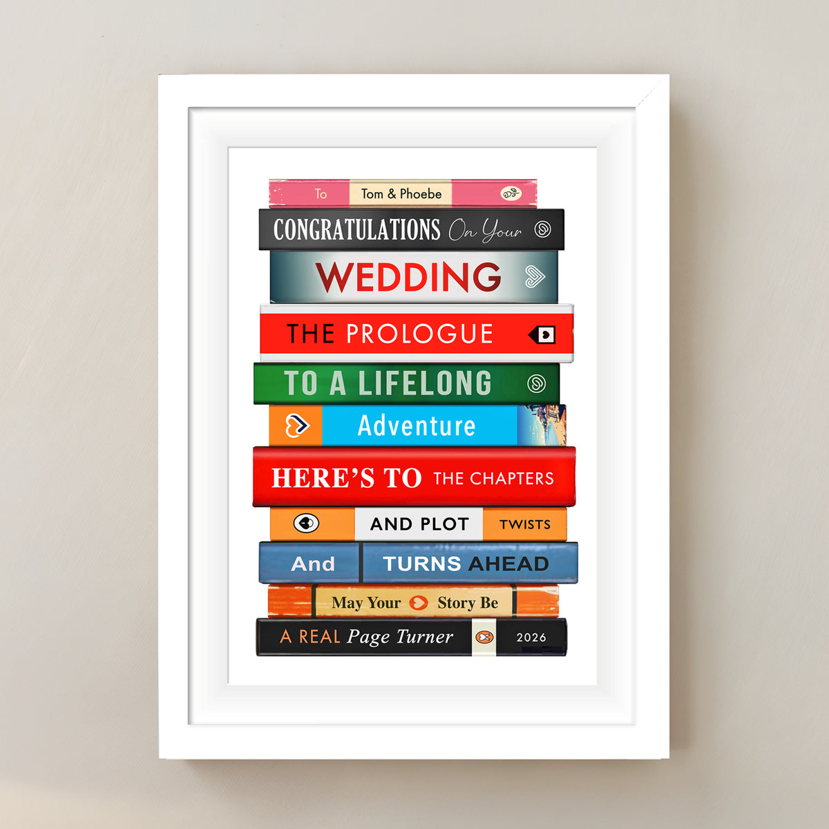 A framed personalised book stack wall art print with wedding-themed book spines and text, displayed on a light beige wall.