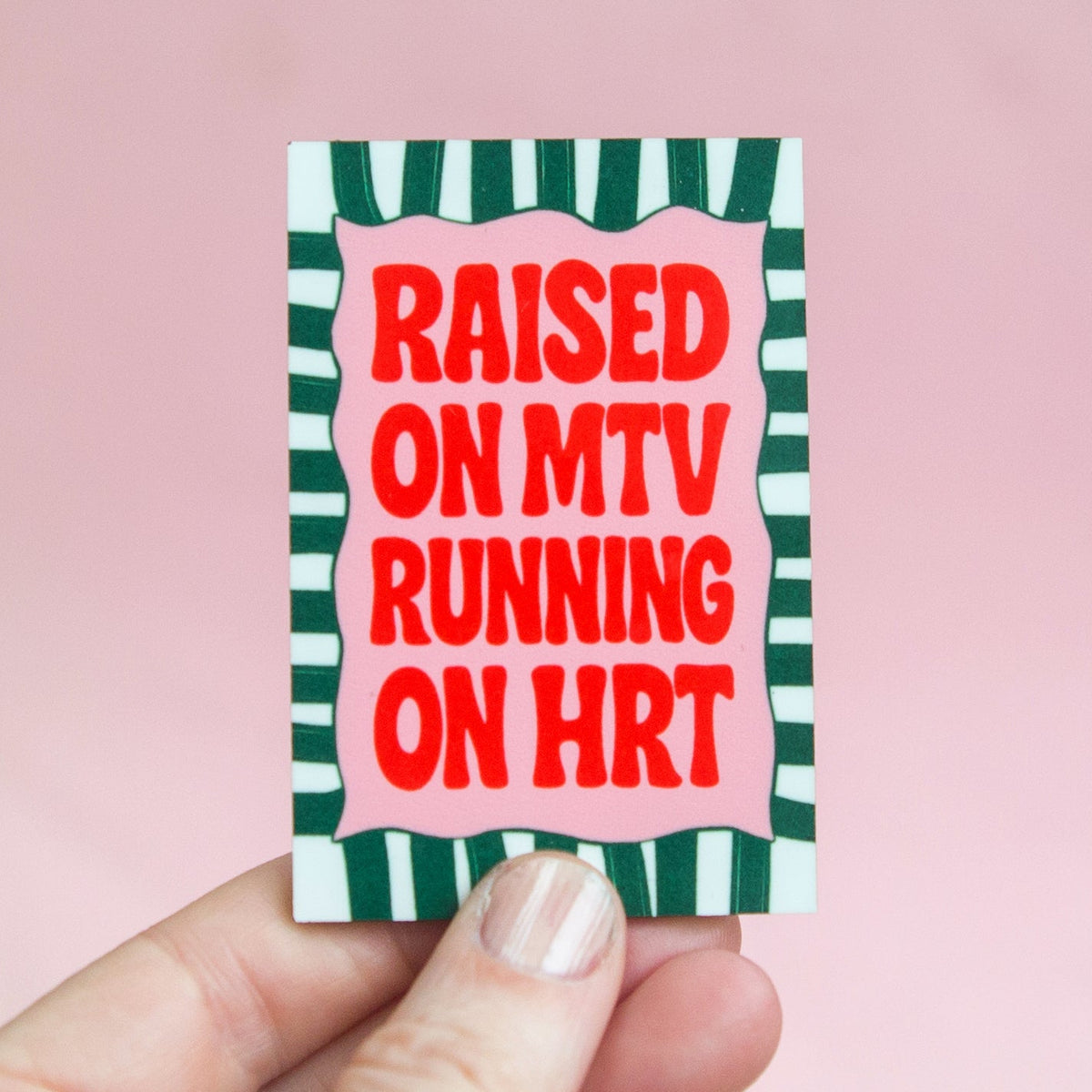 fridge magnet with HRT slogan held in a hand against a pink background
