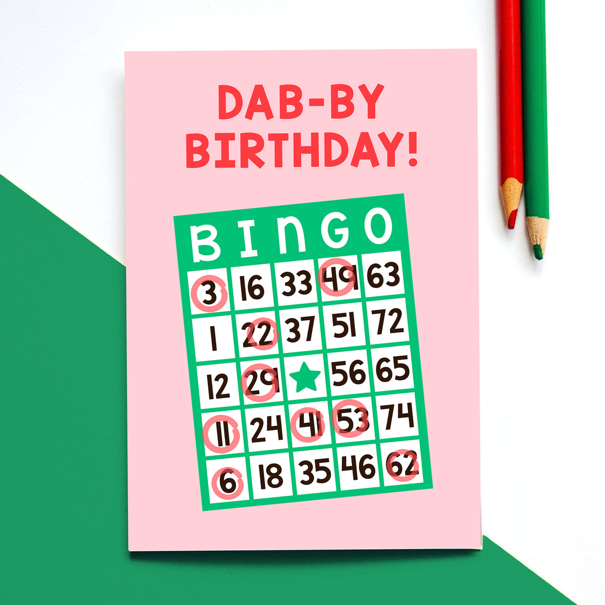 a birthday card on a white and green background illustrated with a bingo card and the words 'Dab-by Birthday'