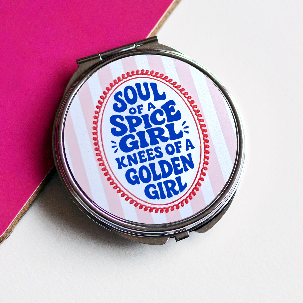 compact mirror with stripe and slogan design against a pink and white background