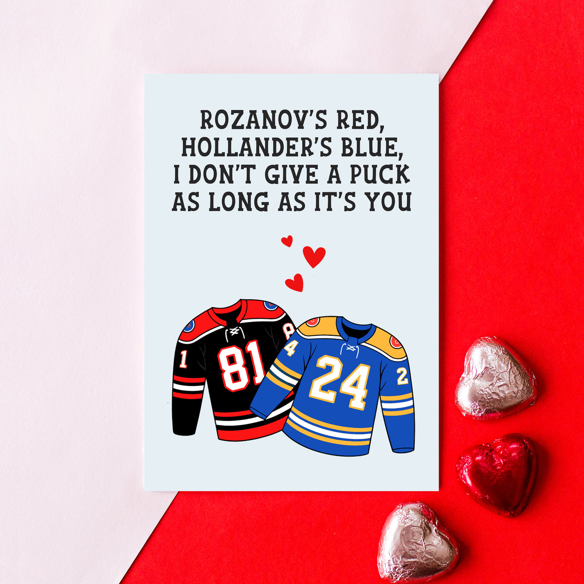 heated rivalry themed card for partner on a pink and red background with pink and red heart shaped chocolates