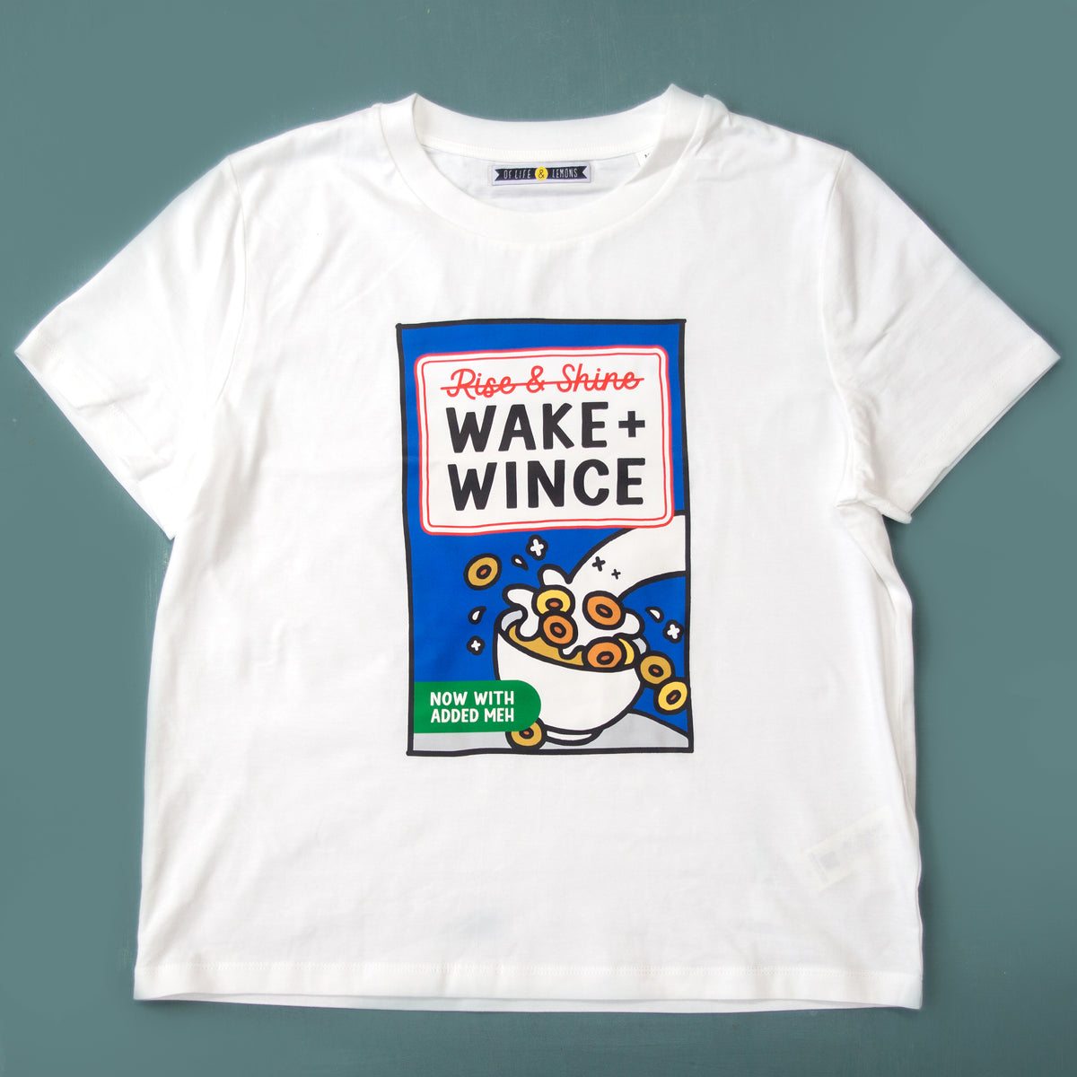 White t-shirt with 'Wake + Wince' graphic design on a gray background