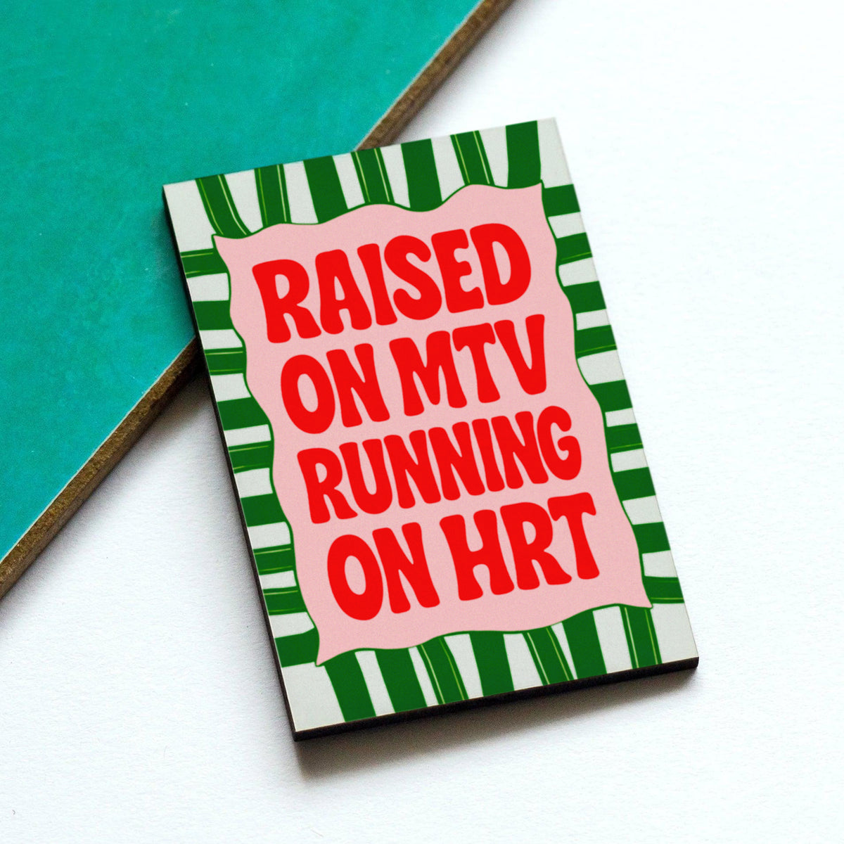 a fridge magnet featuring striped design and slogan 'Raised on MTV running on HRT'