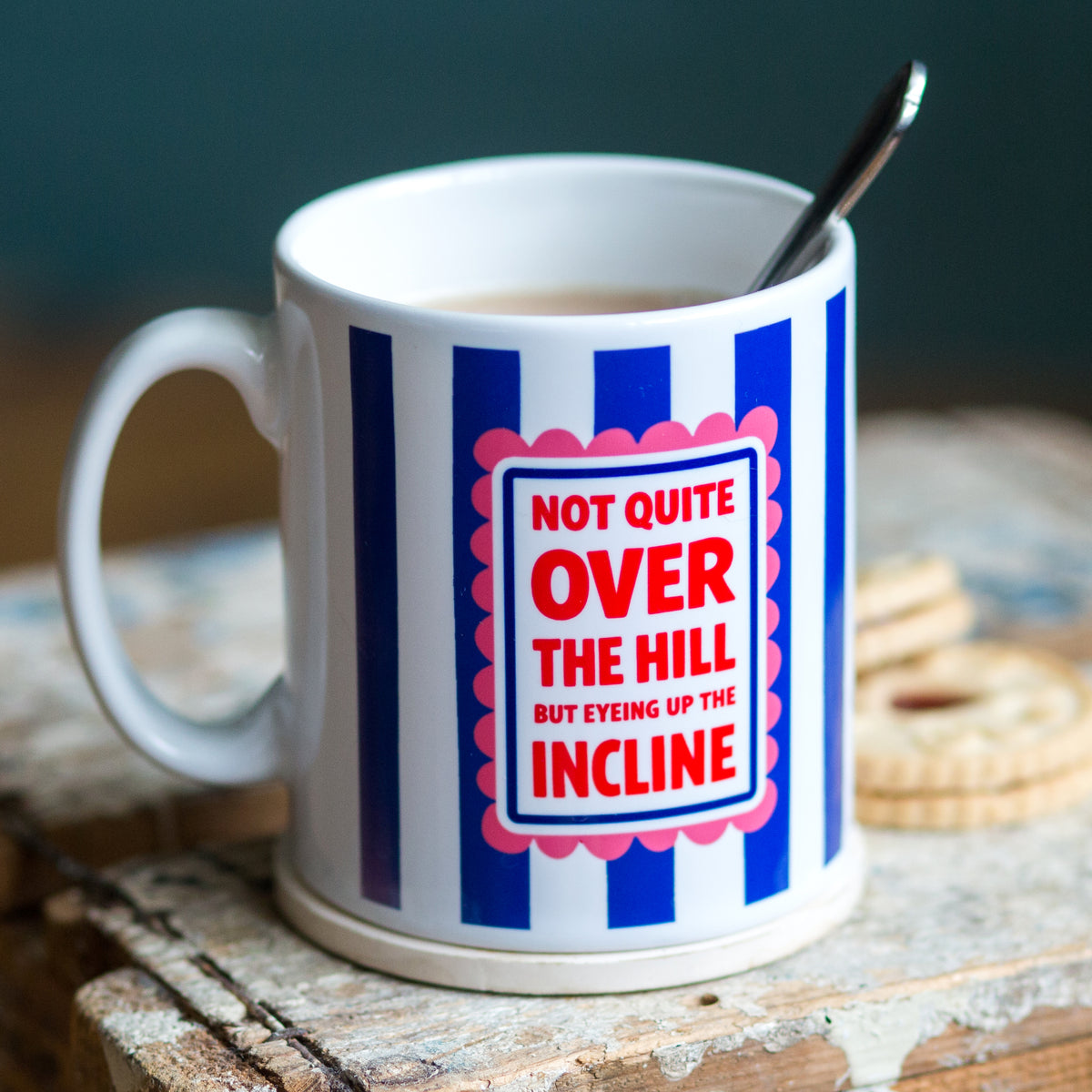 blue and white striped mug with funny ageing slogan on a wooden table