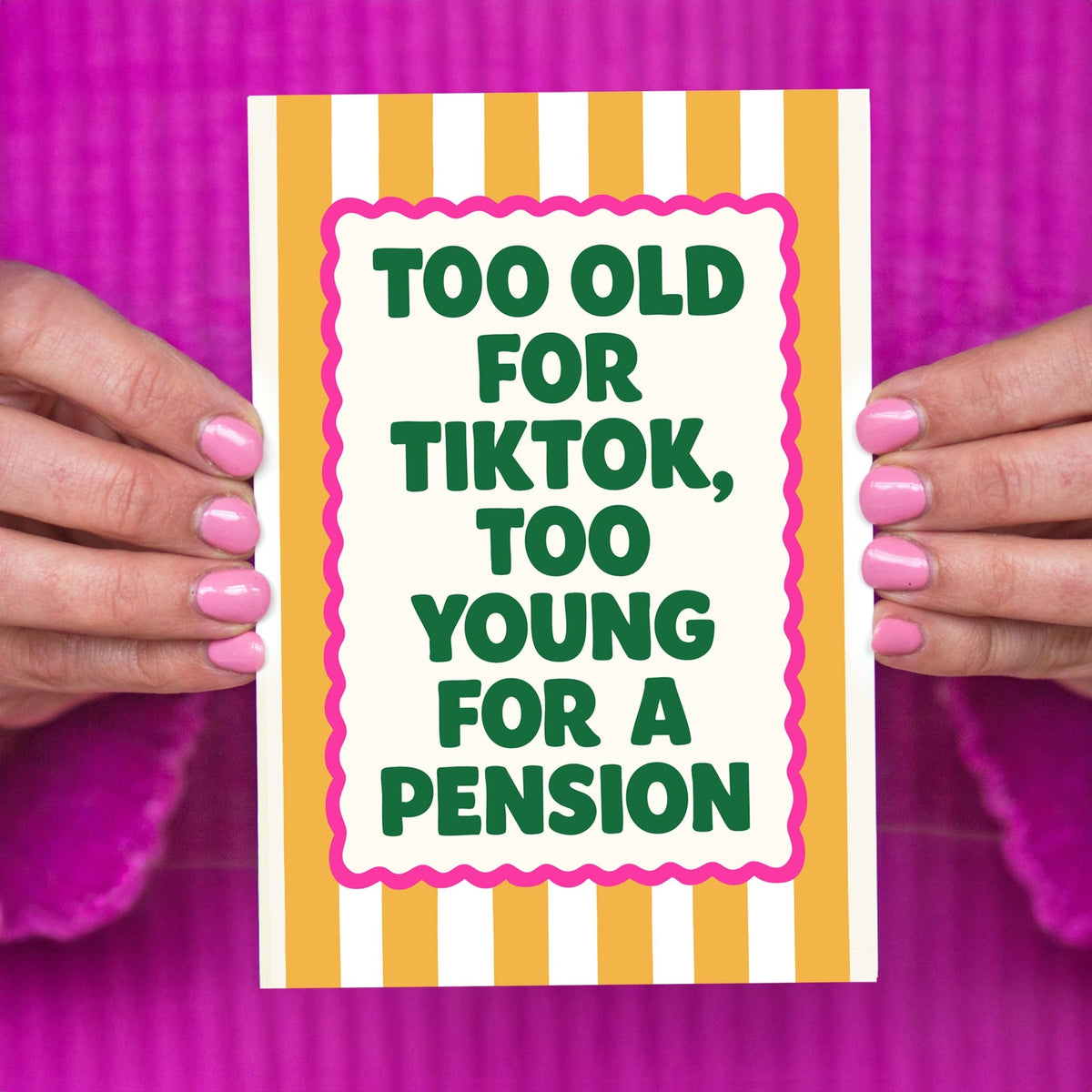 Card with text 'Too old for Tiktok, too young for a pension' held by hands against a pink background