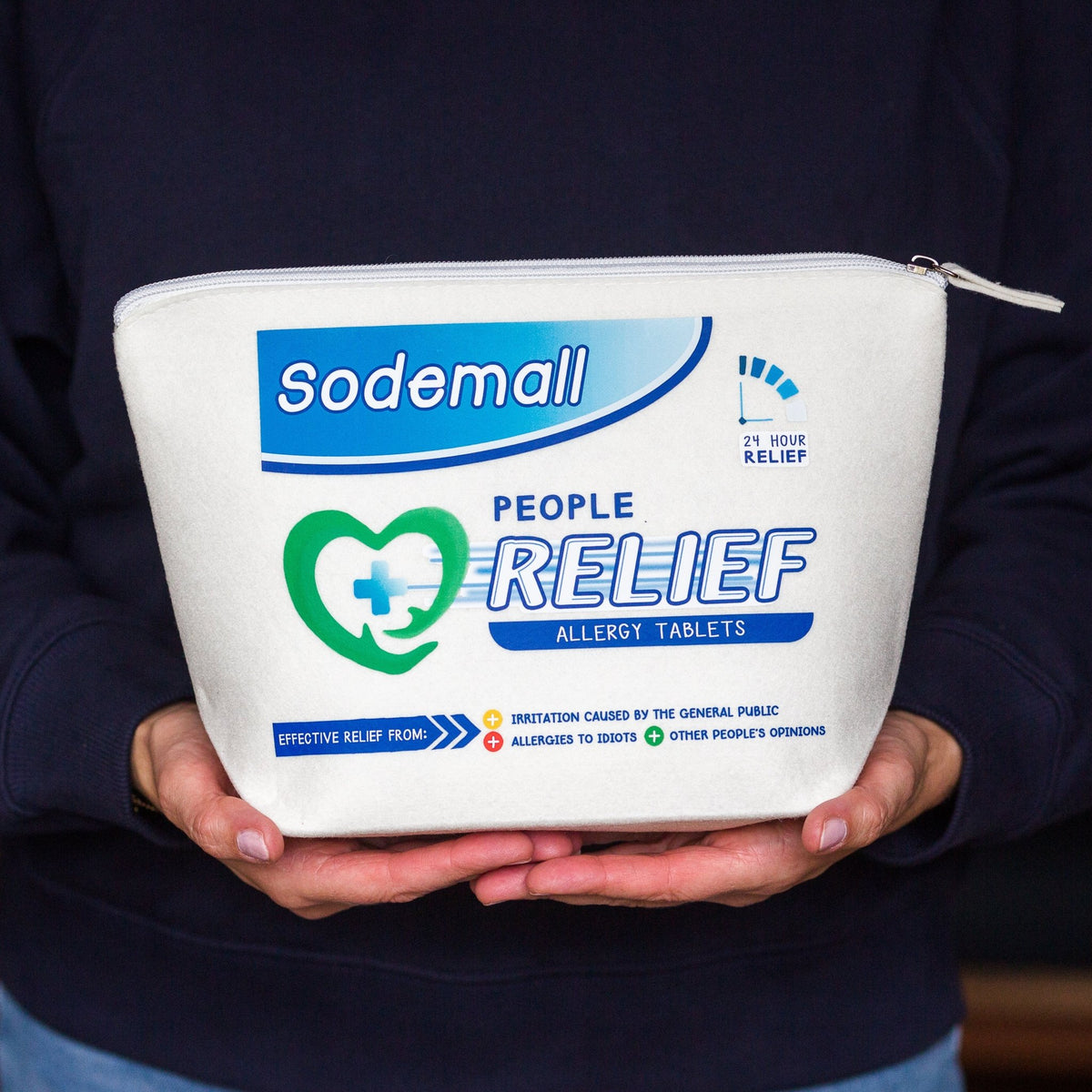 A person holding a white zippered pouch labeled 'Sodemall People Relief Allergy Tablets' against a dark navy sweatshirt background.
