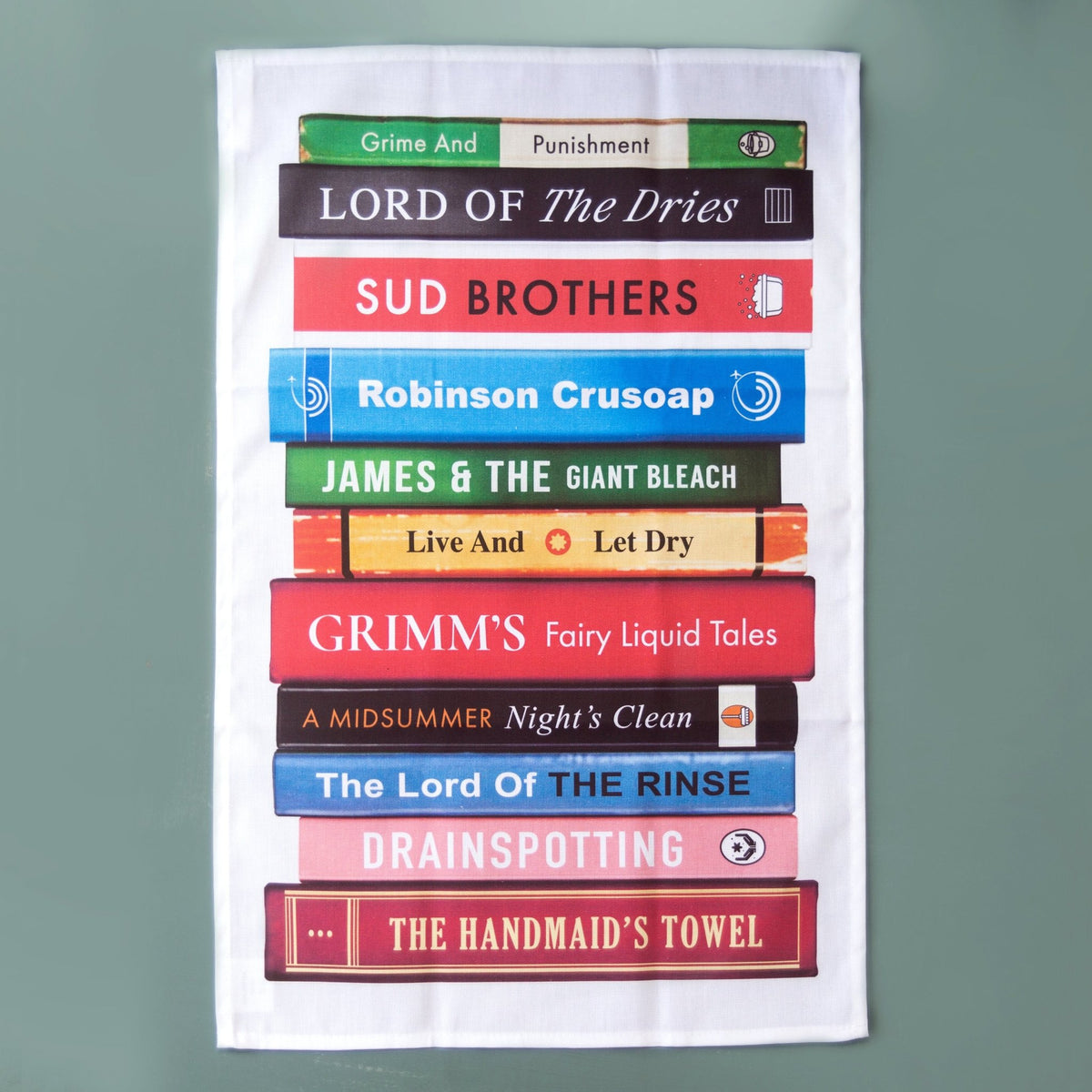 tea towel featuring stack of books with cleaning based literary puns such as grime and punishment against a blue background