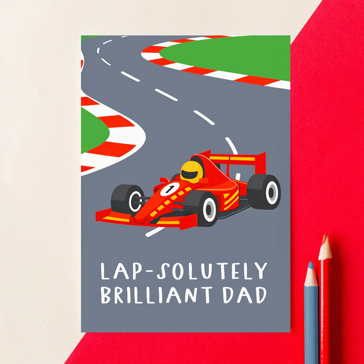 Card with a red racing car on a gray road, featuring the text 'Lap-solutely Brilliant Dad' on a red background.