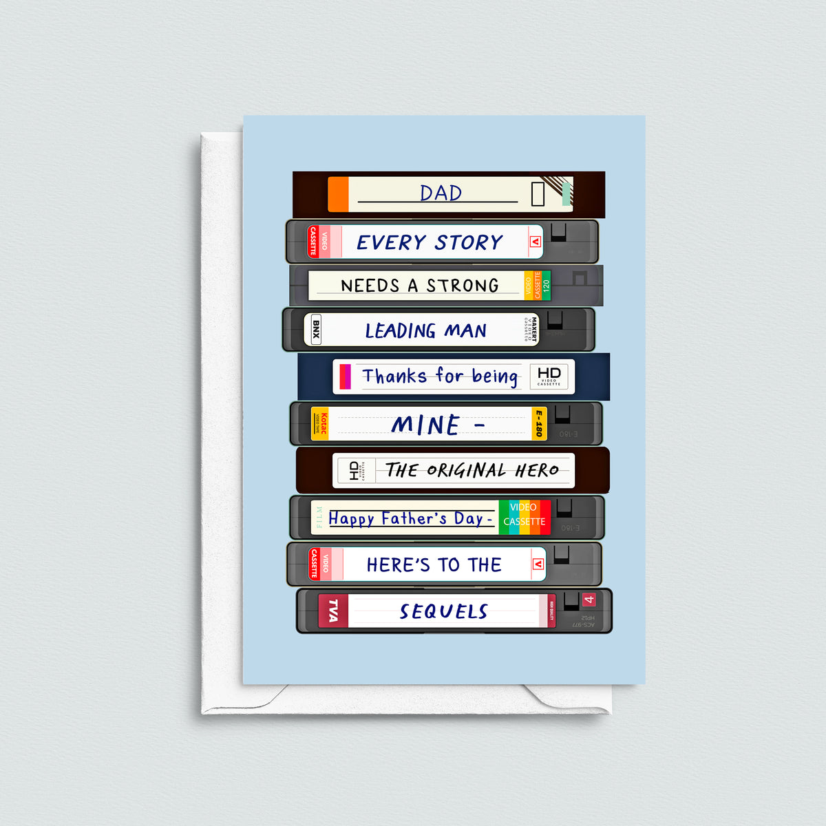 movie themed father's day card featuring VHS cassettes pictured with a white envelope on a grey background