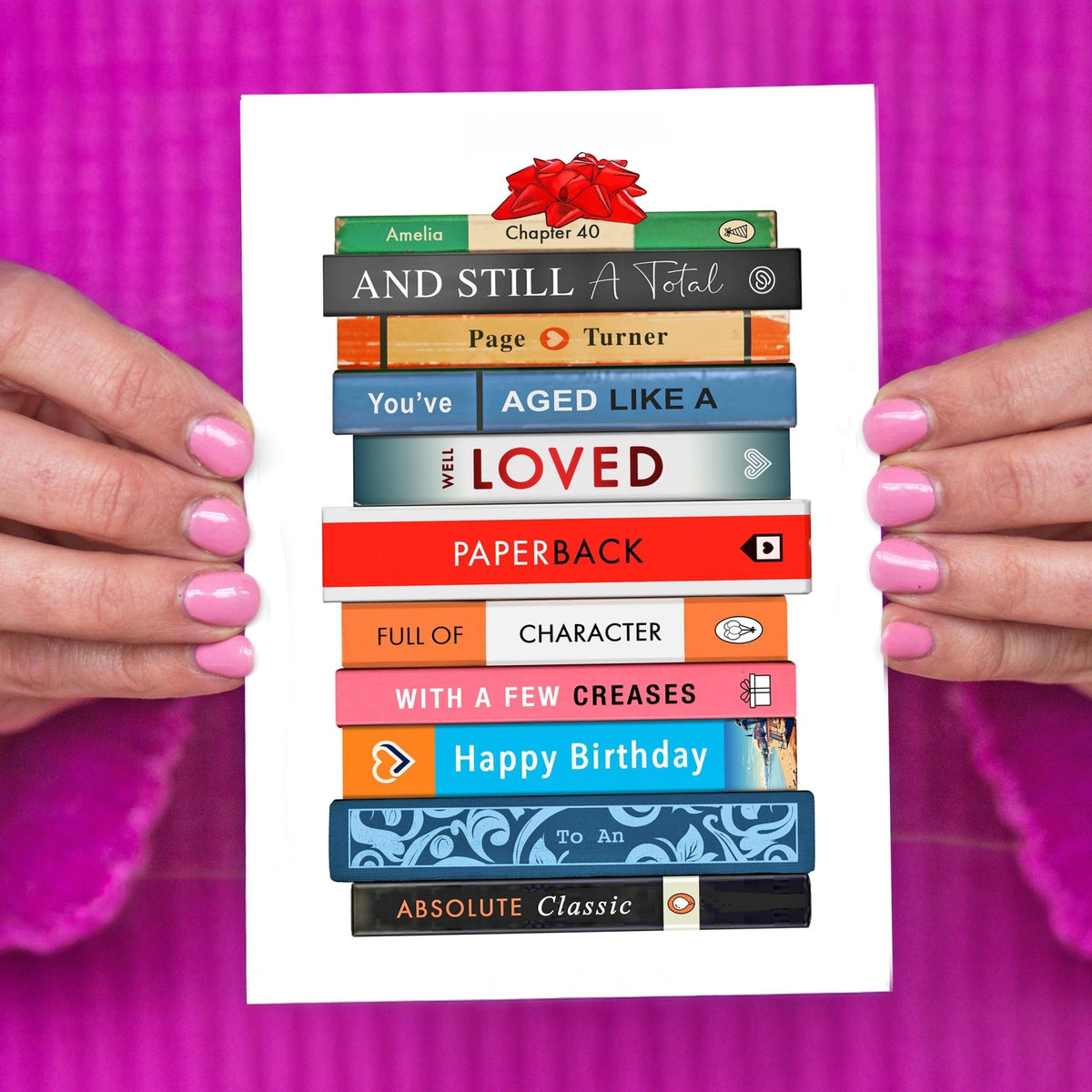 a personalised birthday card featuring an illustration of a stack of books spelling out a book themed birthday message