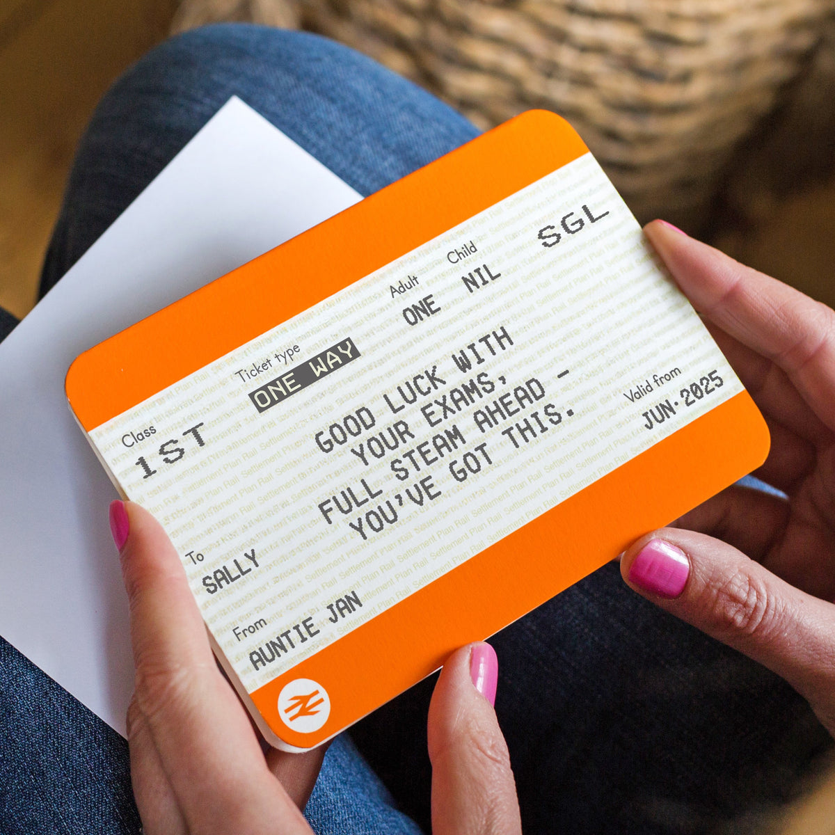 hands holding a greeting card designed to look like a train ticket that features a good luck in exams message and personalised details