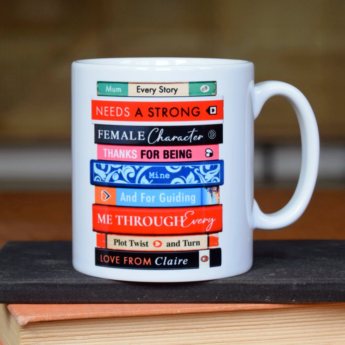 White mug with colorful text design on a wooden surface