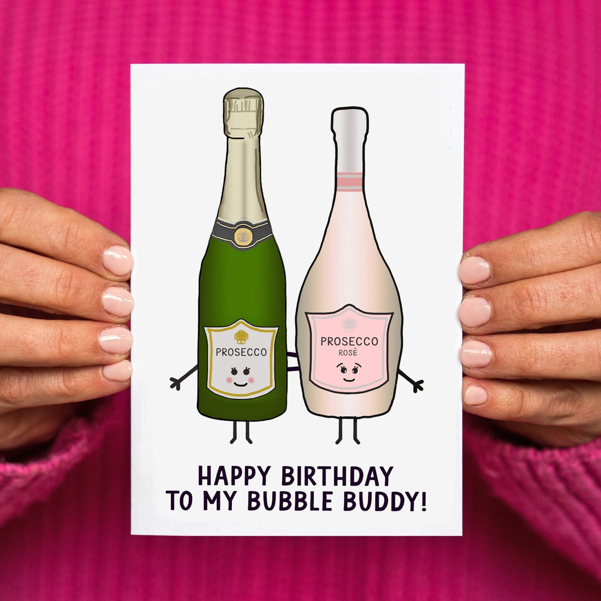 two illustrated bottles of prosecco with a birthday message for a friend held in hands against a pink jumper