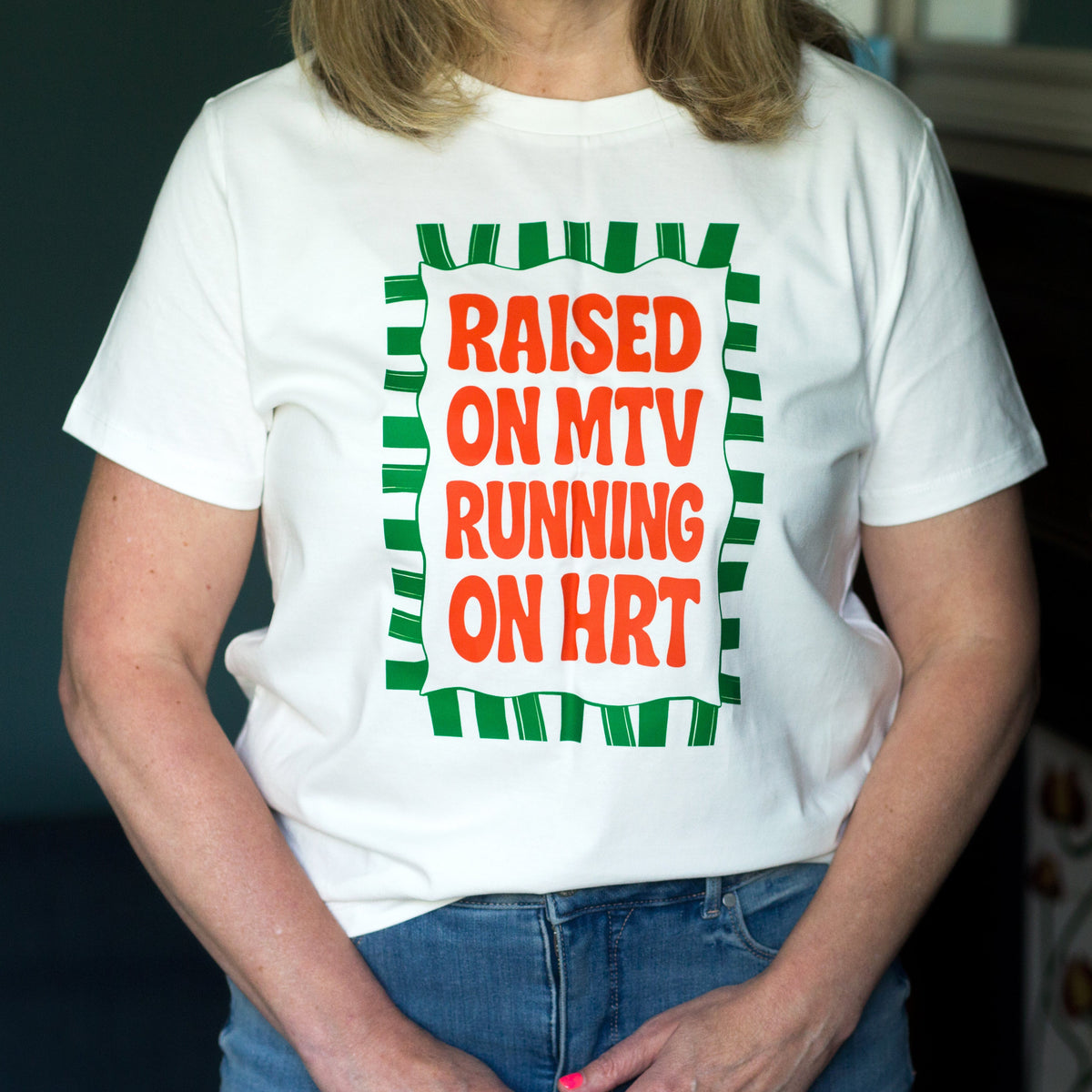 ladies t-shirt featuring the slogan 'Raised on MTV, running on MTV' being modelled on a woman in a lounge setting