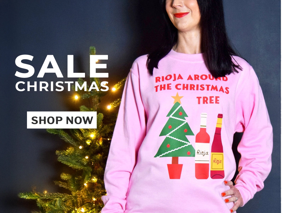an image of a woman in a pink Christmas jumper next toa. christmas tree with text advertising a christmas sale