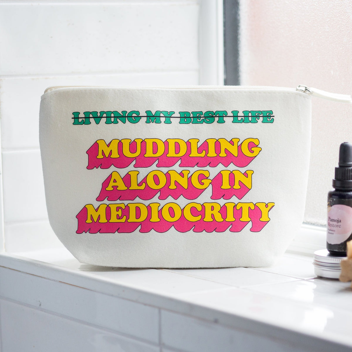 funny cosmetic bag with sarcastic message on a bathroom windowsill