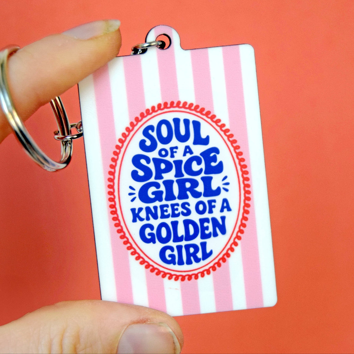 Keychain with 'Soul of a Spice Girl, Knees of a Golden Girl' text on a pink and white striped background