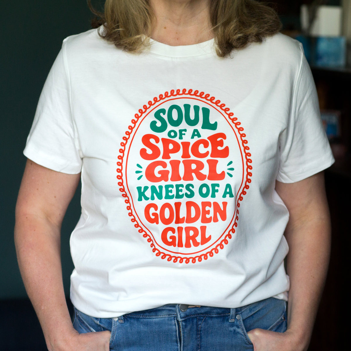 Person wearing a white t-shirt with colorful text design.