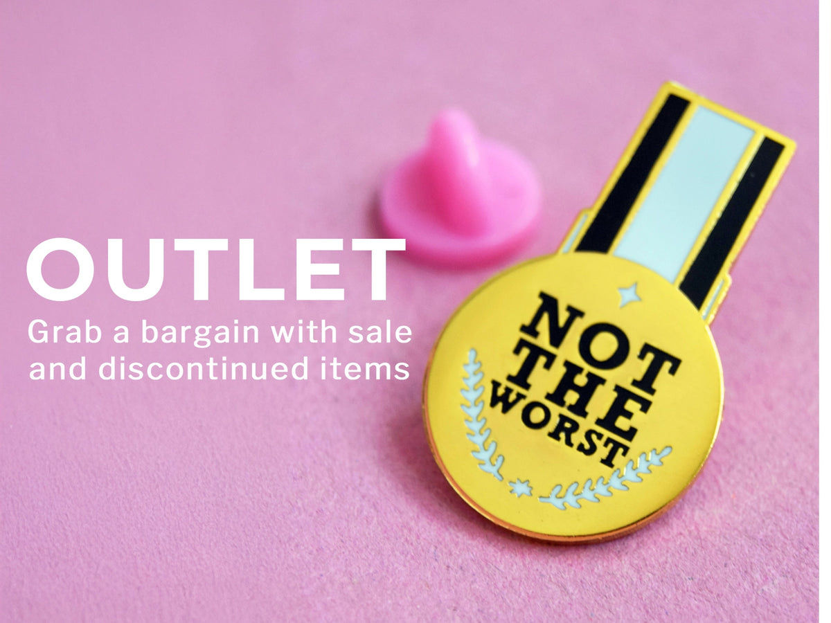 A yellow enamel pin shaped like a medal with the text 'NOT THE WORST' in black, shown on a pink background with a small pink cone-shaped accessory. Large white text on the left reads 'OUTLET Grab a bargain with sale and discontinued items'.