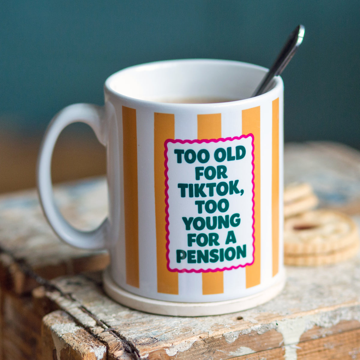 Mug with striped design and humorous text on a wooden surface