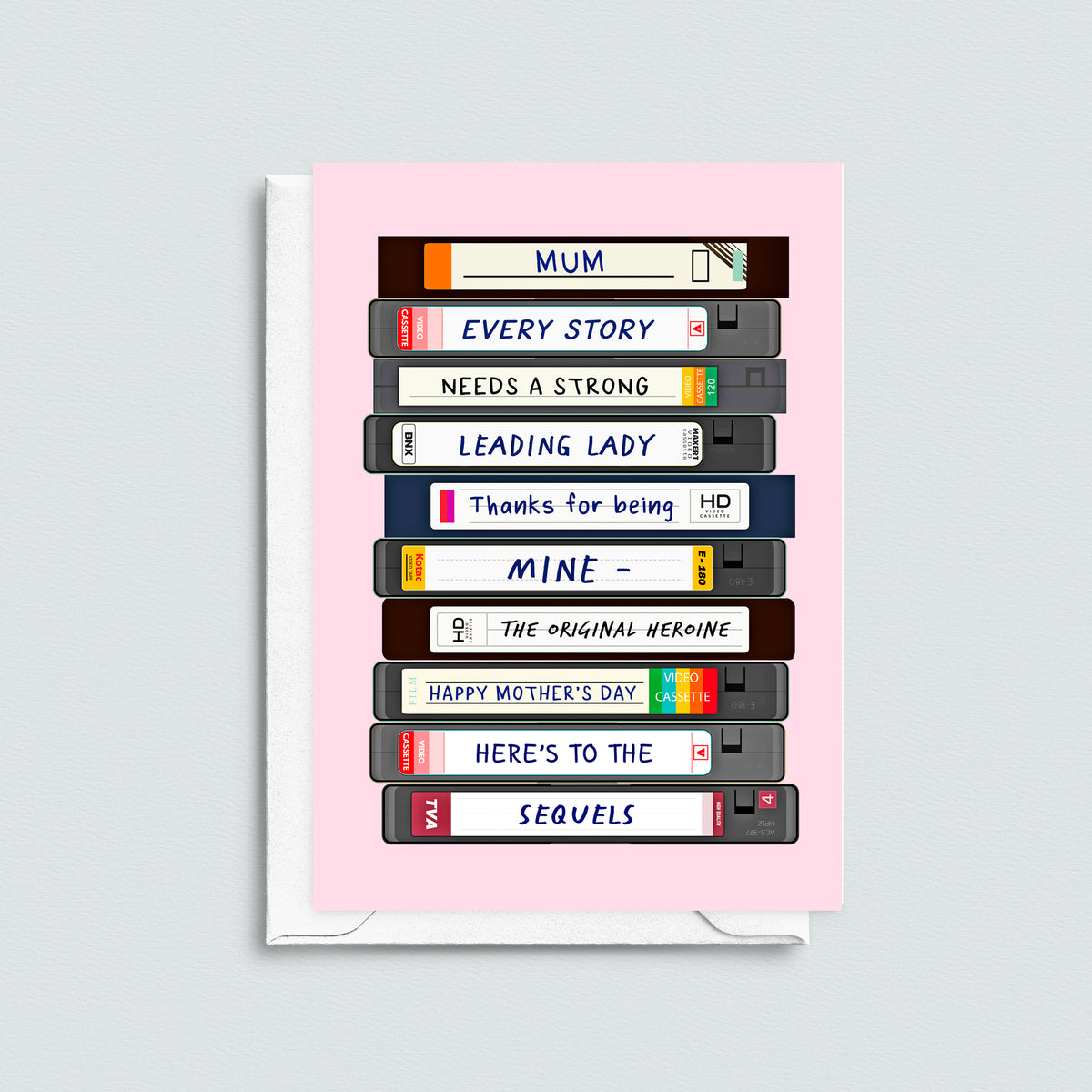mother's day card featuring a stack of vhs spelling out a message for mum, pictured with a white envelope on a grey bacground