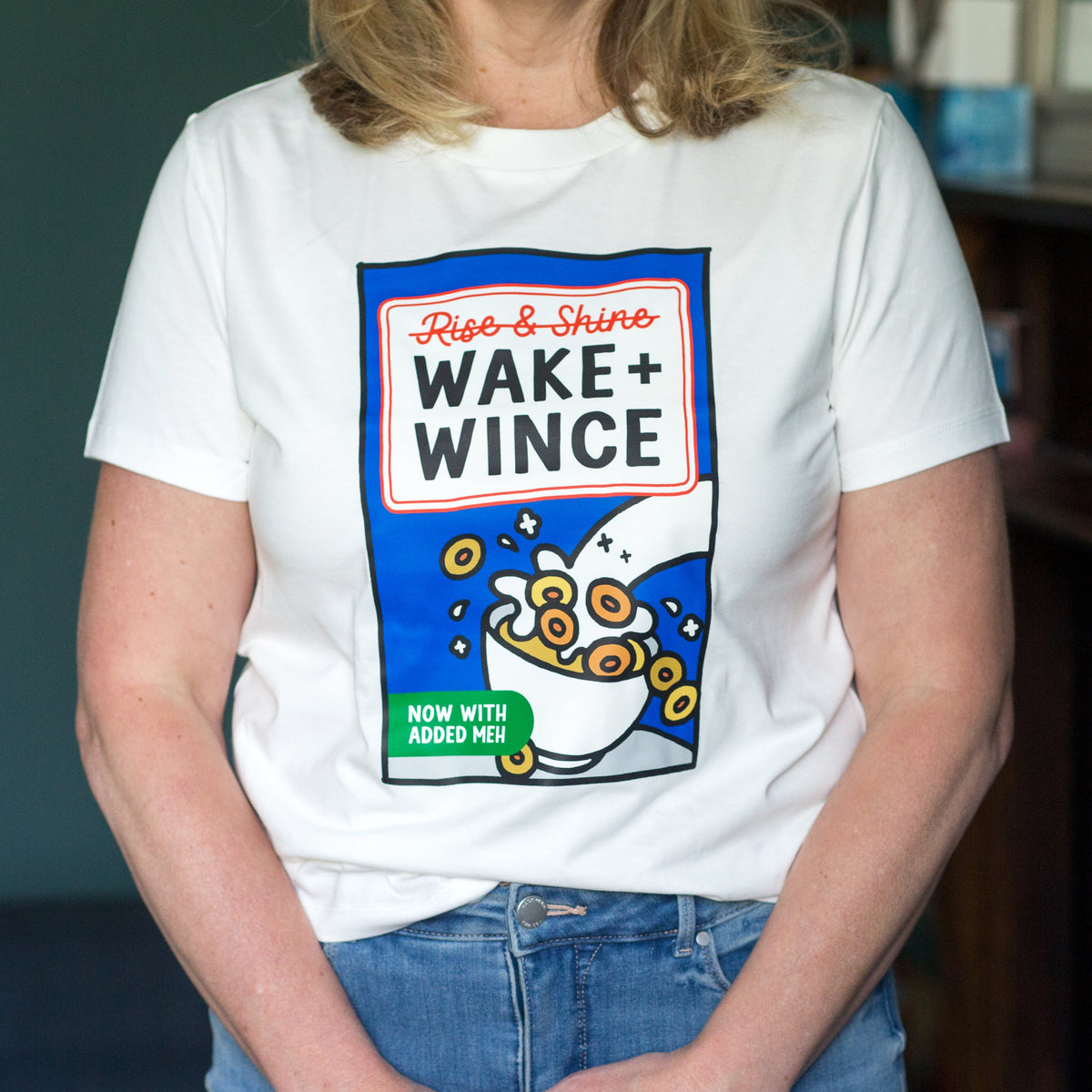 Person wearing a white t-shirt with a colorful graphic design on a dark background