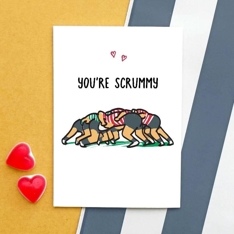 you're scrummy rugby card for partner showing an illustration of a rugby pun with two hearts on a striped background